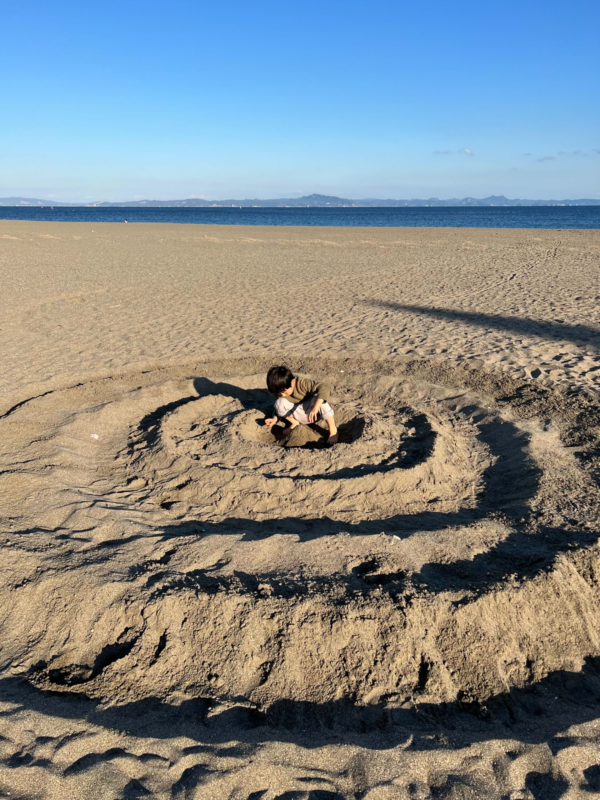 社員のお子さんが砂浜で遊んでいる写真